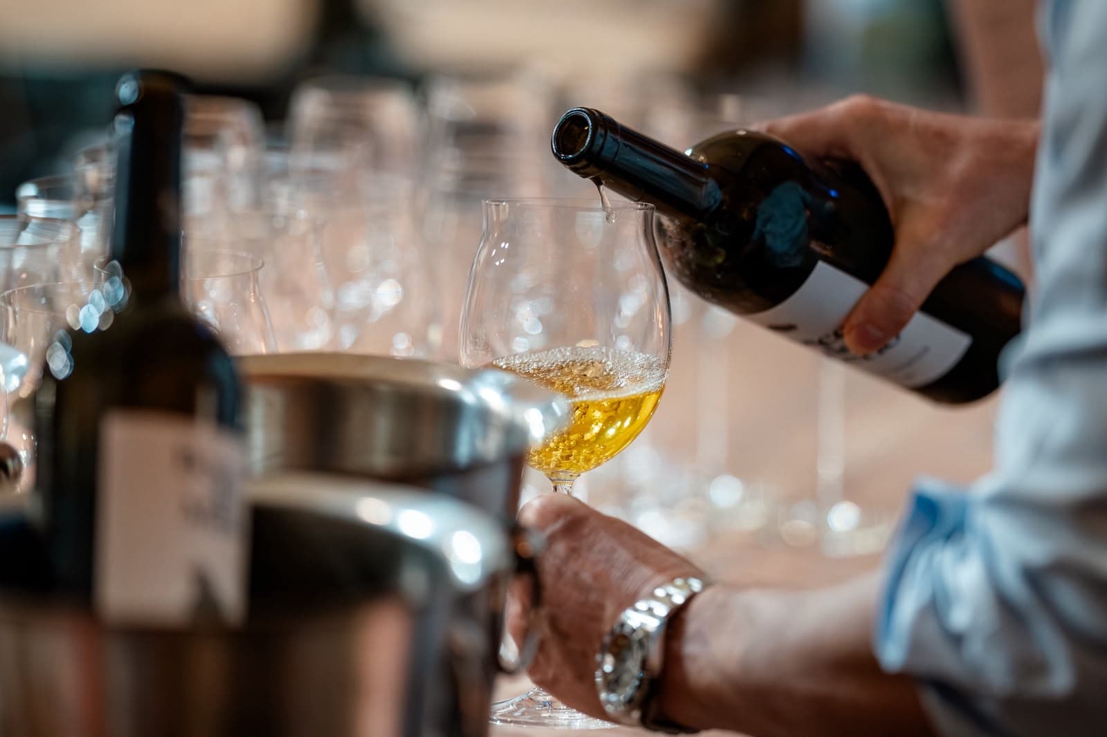Wein wird bei einer Verkostung ins Glas eingeschenkt